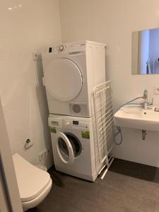 pralka i suszarka w łazience z umywalką w obiekcie Al Nafurah Apartments w Monachium