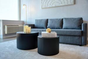 霍博肯Empire State View - Luxury Apt with Pool - Shuttle to NYC的带沙发的客厅设有两张桌子