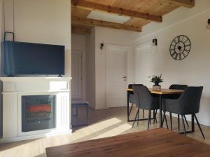 a living room with a fireplace and a table with chairs at Antiva in Livno