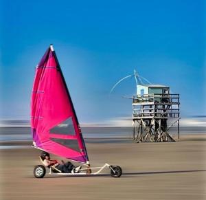 a person riding a boat with a sail on the beach at Studio à St Brévin les pins in Saint-Brevin-les-Pins