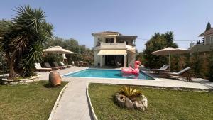 a house with a swimming pool with a pink swan in it at The White Villa in Nydri
