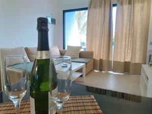 een wijnfles en twee glazen op een tafel in de woonkamer bij A Dream On The Beach Sun Club in Playa del Aguila +31 foto's