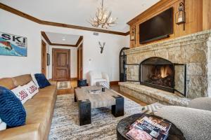 salon z kanapą i kominkiem w obiekcie Ski-in Ski-out 1 BdrDen in exclusive Horizon Pass condo w mieście Avon
