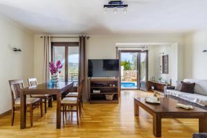 a living room with a couch and a table at Alexandra Pool Villa - Comfort & Views Near Town in Skopelos Town