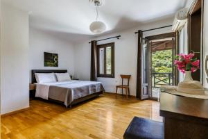 a bedroom with a bed and a wooden floor at Alexandra Pool Villa - Comfort & Views Near Town in Skopelos Town +37 photos