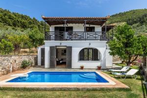 a villa with a swimming pool in front of a house at Alexandra Pool Villa - Comfort & Views Near Town in Skopelos Town