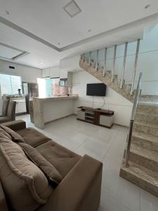a living room with a couch and a staircase at Duplex - Villa dos Diamantes in Porto Seguro