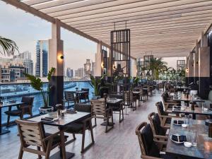 a restaurant with tables and chairs and a view of the city at Hyde Hotel Dubai in Dubai