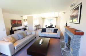 a living room with a couch and a fireplace at Arrowfield Apartments in Arrowtown