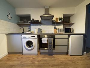 a kitchen with a washer and a washing machine at Fort Cresent Sea View Apartment in Margate