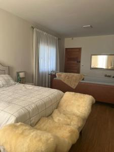 a bedroom with a bed and two ottomans sidx sidx sidx at Lake House_SC in Rio Forcação