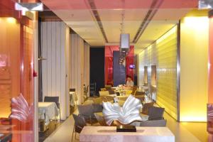 a restaurant with tables and chairs and a person in the background at Jinjiang Inn Shenyang Middle Street Pedestrain in Shenyang