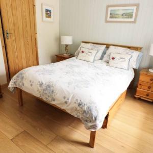 ein Schlafzimmer mit einem großen Bett mit Kissen darauf in der Unterkunft Cnocachanach Cottage in Tarbert + 2 Fotos