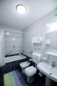 拉多夫利察的住宿－索貝克羅納旅館，浴室配有卫生间、盥洗盆和浴缸。