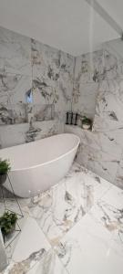 a bathroom with a white tub and marble walls at Bergen Sunrise Terrace Apartment in Bergen +40 photos