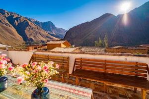 two benches on a balcony with a table and flowers at NUNA SUMAQ Hotel in Ollantaytambo +22 photos