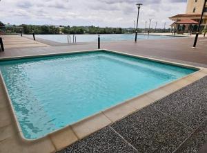 a swimming pool in front of a body of water at AR Homestay Riverine 2 King in Kuching
