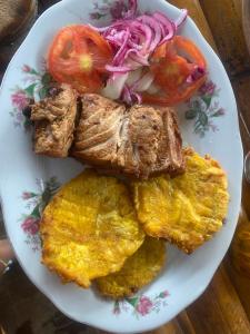 a plate of food with meat and vegetables on a table at Posada mama nati, arusí in Nuquí