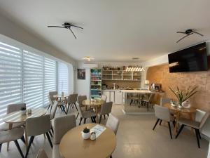 a dining room with tables and chairs and a kitchen at GreenHill Apartments in Kumanovo