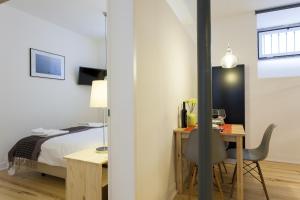 1 dormitorio con cama, mesa y escritorio en JOIVY Cosy 1-bed flat with workspace in Santa Catarina, moments from Luís de Camões Sq, en Lisboa