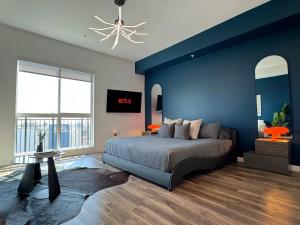 a blue bedroom with a bed and a blue wall at Cosmopolitan Hollywood Home DTLA view Parking - 10mins to Universal Studios in Los Angeles +47 photos