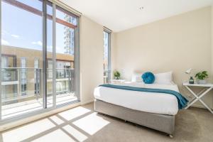 キャンベラにあるModern Two-Story City Pad With Pool, Gym & Saunaのベッドと大きな窓のある寝室 +15枚の写真