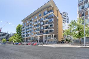 キャンベラにあるModern Two-Story City Pad With Pool, Gym & Saunaの駐車場に車が駐車されている高層ビル