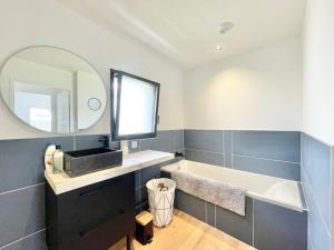 a bathroom with a sink and a tub and a mirror at LA VILLA CAP COZ - 3 Chambres - Plage à 800 m in Fouesnant