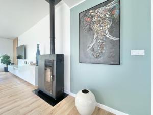 a living room with a fireplace and a painting on the wall at LA VILLA CAP COZ - 3 Chambres - Plage à 800 m in Fouesnant