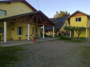 a yellow house with a pavilion in front of it at Villa Casal in Dina Huapi