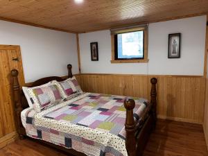 a bedroom with a bed with a quilt on it at l'appartement in Tadoussac