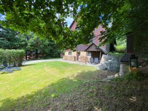 a large yard with a house and a building at Samostatný apartmán se zahradou in Bedřichov