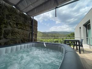 a hot tub on the balcony of a house at Casa da Garrafeira - Quinta da Portela in Terras de Bouro