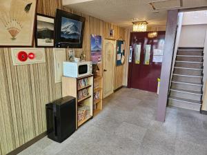 a room with a hallway with a microwave and a door at Plaza Inn Kawaguchiko in Fujikawaguchiko