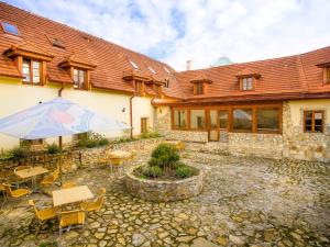 a building with a patio with tables and an umbrella at Hotel Bella in Prague