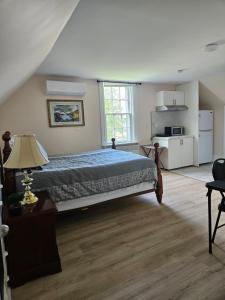 a large bedroom with a bed and a kitchen at Sunflower Guest Suites in Summerside
