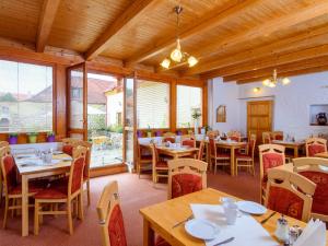 restauracja z drewnianymi stołami, krzesłami i oknami w obiekcie Hotel Bella w Pradze