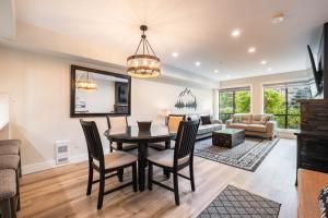 a dining room and living room with a table and chairs at Powderhorn 205 by Outpost Whistler in Whistler