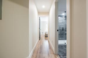 a hallway with white walls and wood floors at Powderhorn 205 by Outpost Whistler in Whistler +41 photos