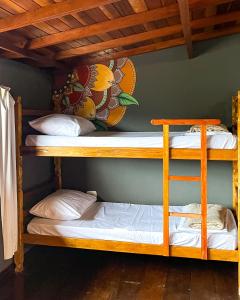 two bunk beds in a room with a wall at Embaúba Paraty - Hostel & Flats in Paraty
