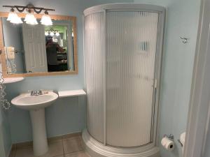 a bathroom with a glass shower and a sink at 12 South Garden View in Georgetown +25 photos