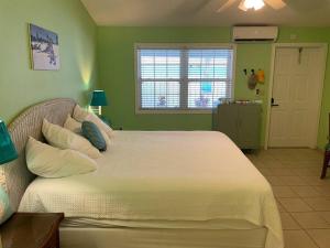 a bedroom with a large bed with green walls at 12 South Garden View in Georgetown