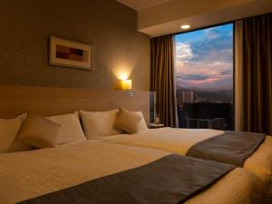 a bedroom with a large bed with a large window at Hotel Gracery Sapporo in Sapporo