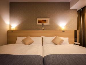 a large bed with white sheets and pillows at Hotel Gracery Sapporo in Sapporo