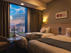 a hotel room with two beds and a large window at Hotel Gracery Sapporo in Sapporo