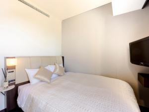 a bedroom with a bed and a flat screen tv at Hotel Gracery Sapporo in Sapporo