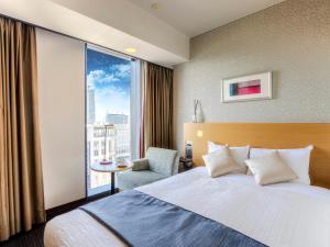 a hotel room with a bed and a large window at Hotel Gracery Sapporo in Sapporo