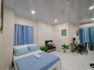 a bedroom with a blue bed and a tv in it at Quirino hub (404) in Davao City