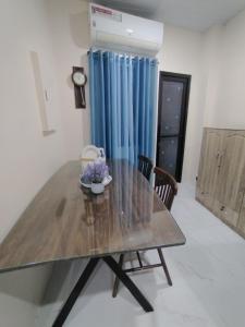 a dining room with a wooden table and blue curtains at Quirino hub (404) in Davao City