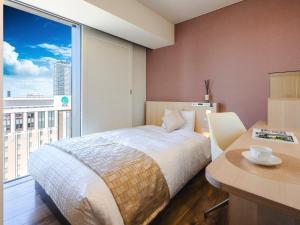 a bedroom with a bed and a large window at Hotel Gracery Sapporo in Sapporo